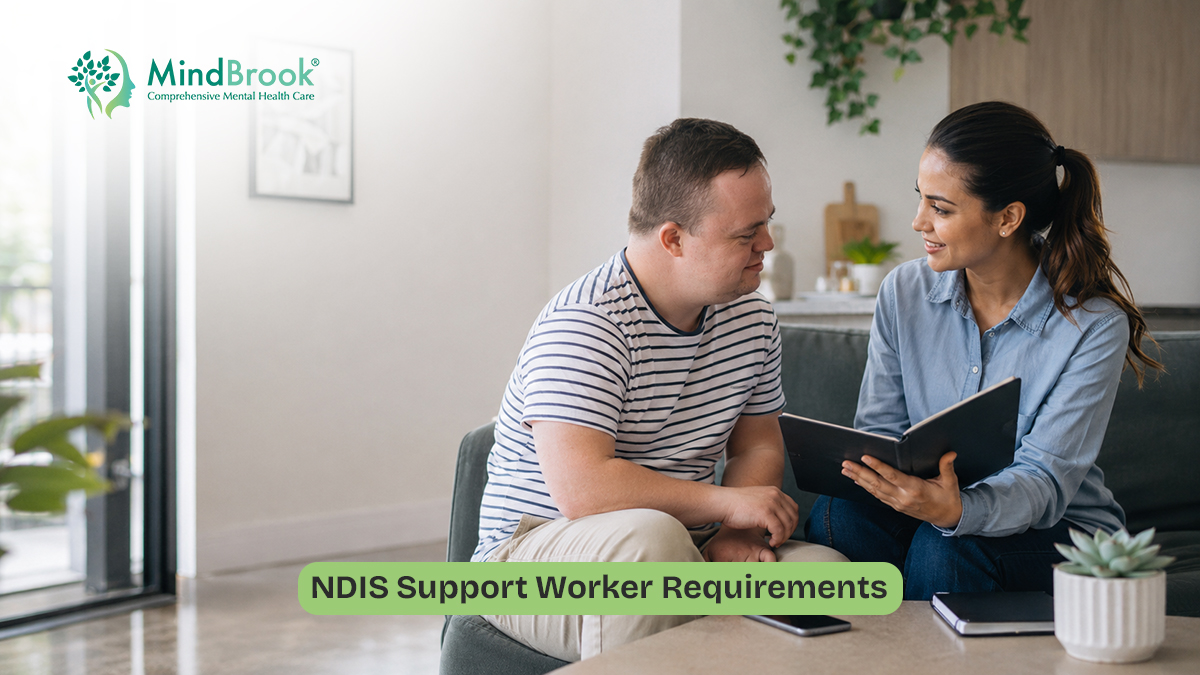 NDIS support worker speaking with an adult participant in a person-centred support setting in Australia.